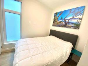 ein Schlafzimmer mit einem Bett und einem Wandgemälde in der Unterkunft Perfect Brand New Condo In The Heart of Sidney in Sidney