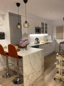 a kitchen with a marble counter and chairs in it at Apartamento a 100metros de la playa de San Lorenzo in Gijón