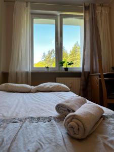 een bed met handdoeken voor twee ramen bij Sopot Sea Apartments in Sopot