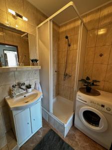een badkamer met een wasmachine en een douche bij Sopot Sea Apartments in Sopot