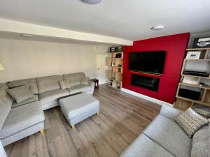 a living room with a couch and a flat screen tv at The Arch Accommodation in Carrick-on-Suir