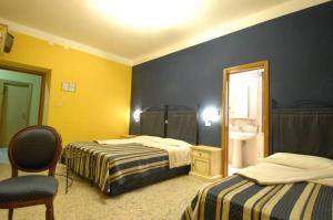 una camera d'albergo con due letti e una finestra di Hotel Ede a Caramanico Terme