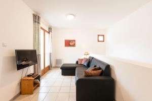 a living room with a couch and a tv at La Tour de Guet in Montbrun-les-Bains