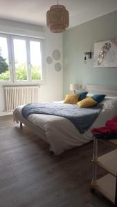 um quarto com uma cama grande com almofadas azuis e amarelas em Ti sterennou Maison néo bretonne rénovée proche axe Paris Brest RN12 et tgv 