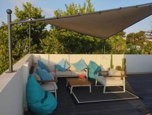 une terrasse avec un canapé et des chaises sous un parasol dans l'établissement Maravillosos Atico, à Godella