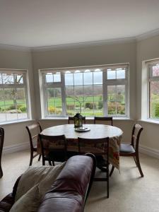 a living room with a table and chairs and windows at Hillside House- Pine View in Ballinamuck