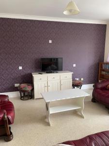 a living room with a tv and a white coffee table at Hillside House- Pine View in Ballinamuck