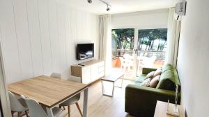uma sala de estar com um sofá verde e uma mesa em Primera línea y vistas al mar con piscina em L'Estartit