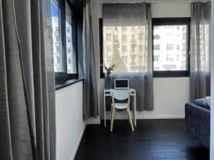 Luxury Waterfront Apartment في برلين: غرفة صغيرة مع مكتب وجهاز كمبيوتر محمول على طاولة