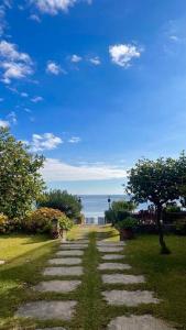 un sentiero di pietra che conduce all'oceano in una giornata di sole di Blue Taormina Holiday a Letoianni Altre 18 foto