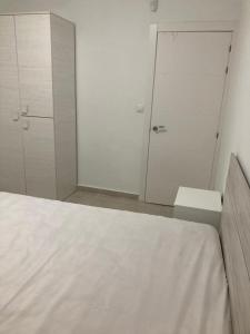 - une chambre avec un lit blanc et un grand miroir dans l'établissement Apartamento en Cambrils, à Cambrils