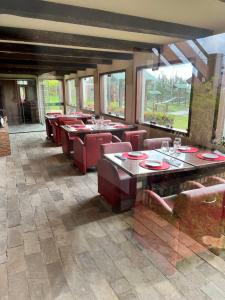 a restaurant with red chairs and tables and windows at Monte Castelo Flat 08B in Gravatá