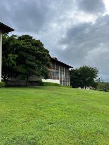 a building with a tree in the middle of a field at Monte Castelo Flat 08B in Gravatá