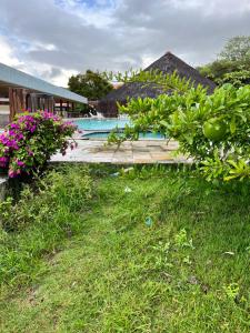 a swimming pool next to a resort with flowers at Monte Castelo Flat 08B in Sairé
