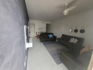 a living room with a couch and a ceiling fan at Beach House in Guarujá