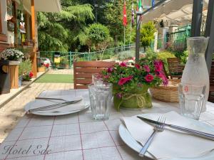 un tavolo con piatti e argenteria e fiori di Hotel Ede a Caramanico Terme