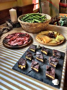 a table with a plate of food and a basket of vegetables at Hotel Ede in Caramanico Terme