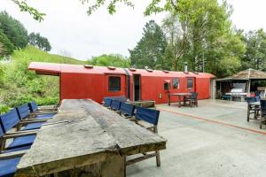 a red trailer with blue chairs and a table at Tiny House Train-Eco stay in Upper Hutt