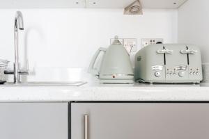 dos tostadoras sentadas en una encimera junto a un fregadero en Lovely one bed duplex flat, en Bournemouth 10 fotos más