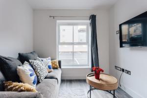 Una sala de estar con un sofá y una ventana. en Lovely one bed duplex flat, en Bournemouth