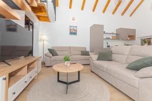 a living room with a couch and a tv at Holiday Home Parona in Šibenik