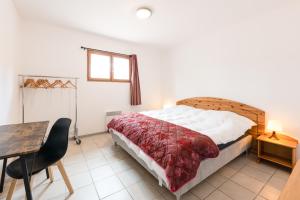 een slaapkamer met een bed en een tafel en een tafel sidx sidx sidx bij La Tour de Guet in Montbrun-les-Bains