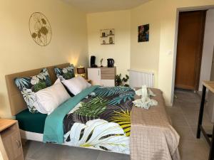 a bedroom with a large bed with a tropical blanket at Studio de Célestine in Vernon