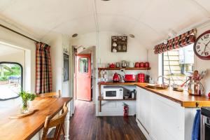 a kitchen with a counter top and a stove top oven at Tiny House Train-Eco stay in Upper Hutt +28 photos