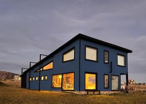 a blue house with many windows in a field at Casa Aoni in Puerto Natales