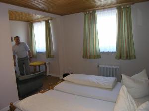 a man standing in a hotel room with two beds at Gasthof am See in Seedorf