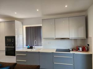 een keuken met witte kasten en een aanrecht bij Paradigm Court, Luxury 2-Bedroom Apartment F3, Oxford in Oxford