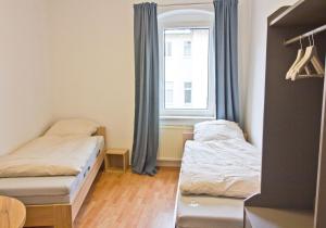 two beds in a small room with a window at Ara Monteursunterkunft, Ferienwohnung Halle Giebichenstein in Giebichenstein