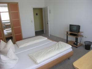 a room with two beds and a television at Gasthof am See in Seedorf