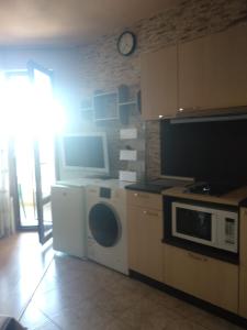 a kitchen with a washing machine and a microwave at Smile in Burgas