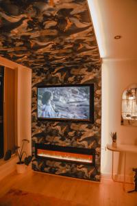 een woonkamer met een tv aan de muur bij The Opulence in Bradford