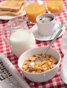 a bowl of cereal and a cup of milk on a table at Mac’s in Belfast