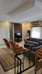 uma sala de estar com um sofá e cadeiras e um piano em A nice villa Near the city and the AirPort and the beach em Dalaman