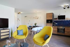 sala de estar con sillas amarillas y cocina en Bernstein Kattegat Apartment 8, en Büsum