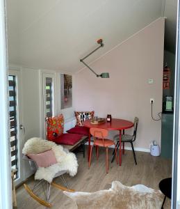 sala de estar con mesa roja y sillas en Daalders Plakkie, en Elahuizen