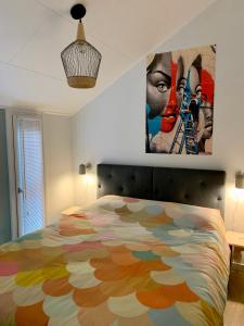Schlafzimmer mit farbenfrohem Bett und Wandgemälde in der Unterkunft Daalders Plakkie in Elahuizen