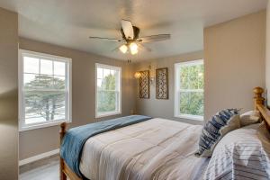 a bedroom with a bed with a ceiling fan and windows at Riverfront Two Rivers Vacation Rental By Beaches in Two Rivers