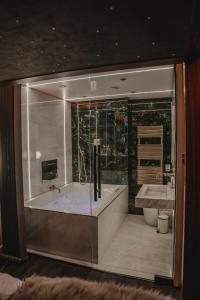 een grote badkamer met een bad en een wastafel bij The Opulence in Bradford