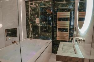 een badkamer met een bad, een douche en een wastafel bij The Opulence in Bradford