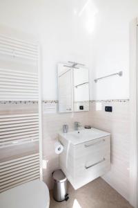 Baño blanco con lavabo y aseo en B&B Castello Cimbergo, en Cimbergo