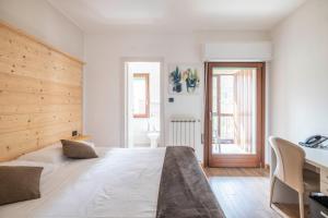 1 dormitorio con 1 cama grande y escritorio en B&B Castello Cimbergo, en Cimbergo