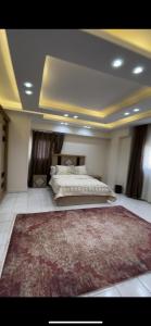 een slaapkamer met een bed en een tapijt op de vloer bij شقة مفروشة فى المهندسين in Caïro