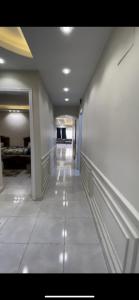 pasillo en un edificio con paredes blancas y suelo de baldosa en شقة مفروشة فى المهندسين en El Cairo