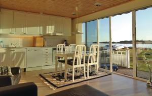セルヴェスボリにあるAwesome Home In Slvesborg With House Sea Viewのキッチン(テーブル、椅子付)、大きな窓が備わります。