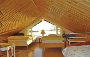Cette chambre mansardée comprend 4 lits et une fenêtre. dans l'établissement Awesome Home In Slvesborg With House Sea View, à Sölvesborg