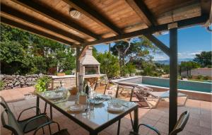 - une table et des chaises sur une terrasse à côté de la piscine dans l'établissement Cozy Home In Mudri Dolac With Kitchen, à Basina